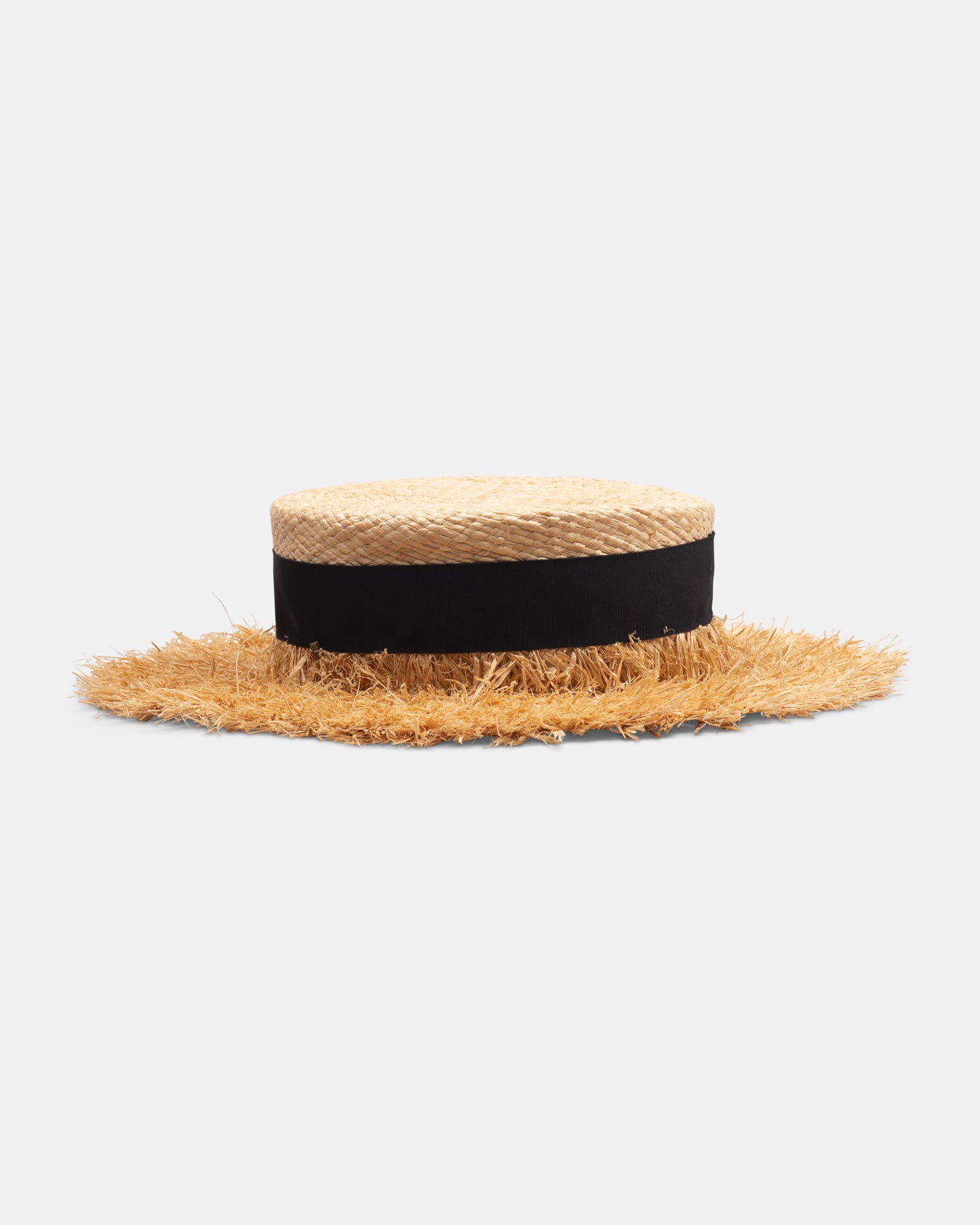 Handmade straw boater hat with frayed brim and wide black ribbon band on white background