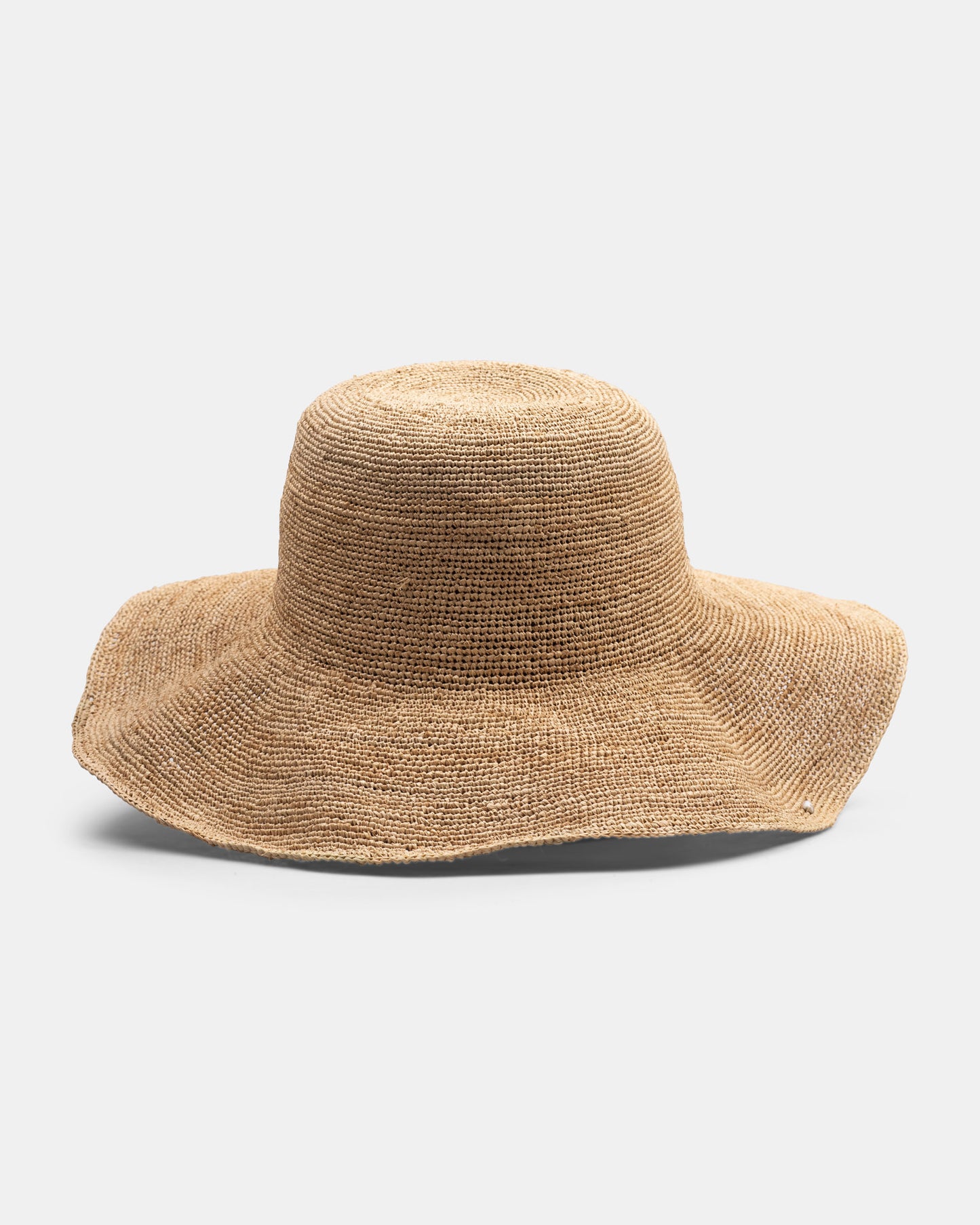 Wide-brimmed natural straw hat with textured weave on a plain white background