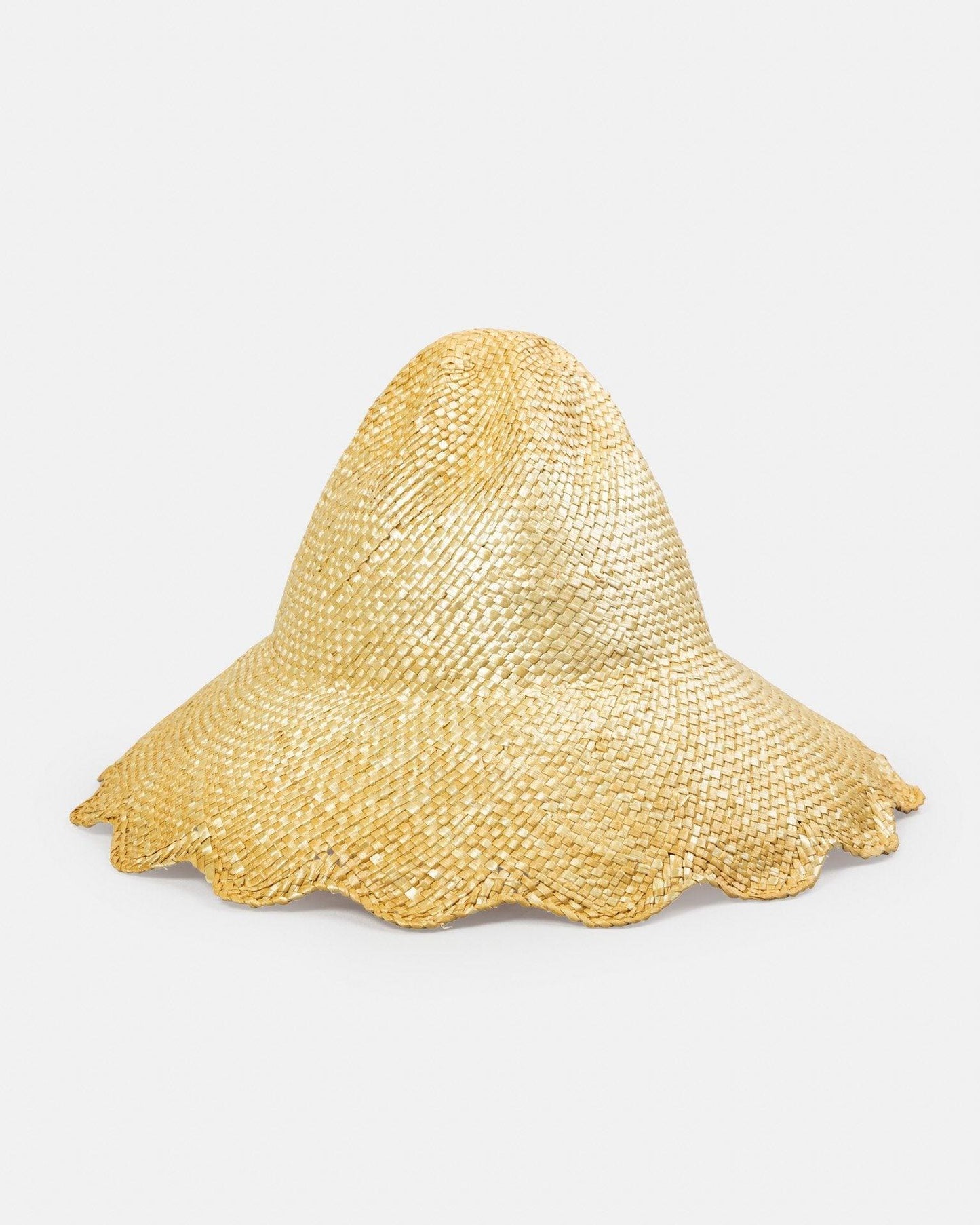 Natural straw cloche hat with wavy brim on white background