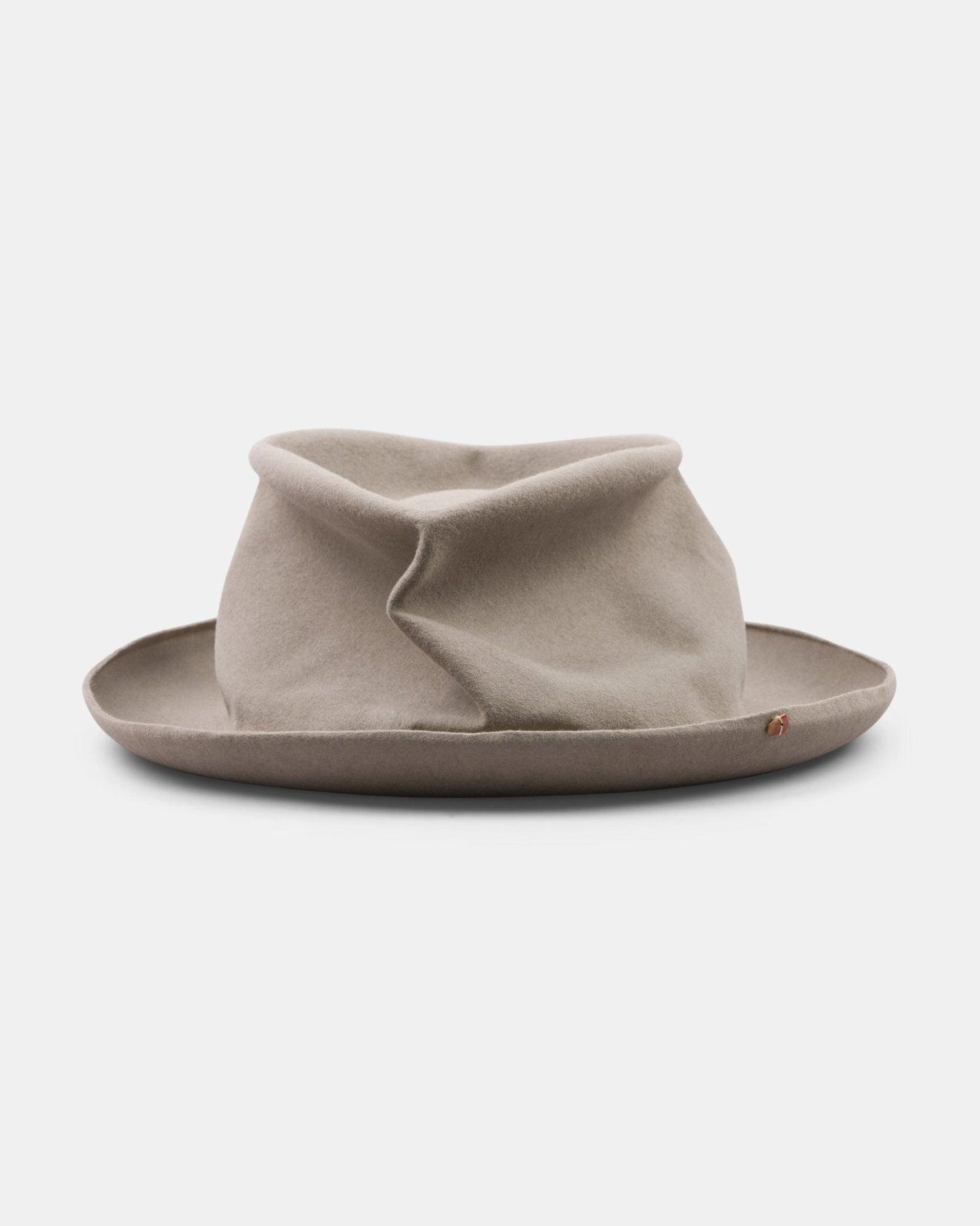 Light tan handmade felt hat with wide brim and unique creased crown on white background