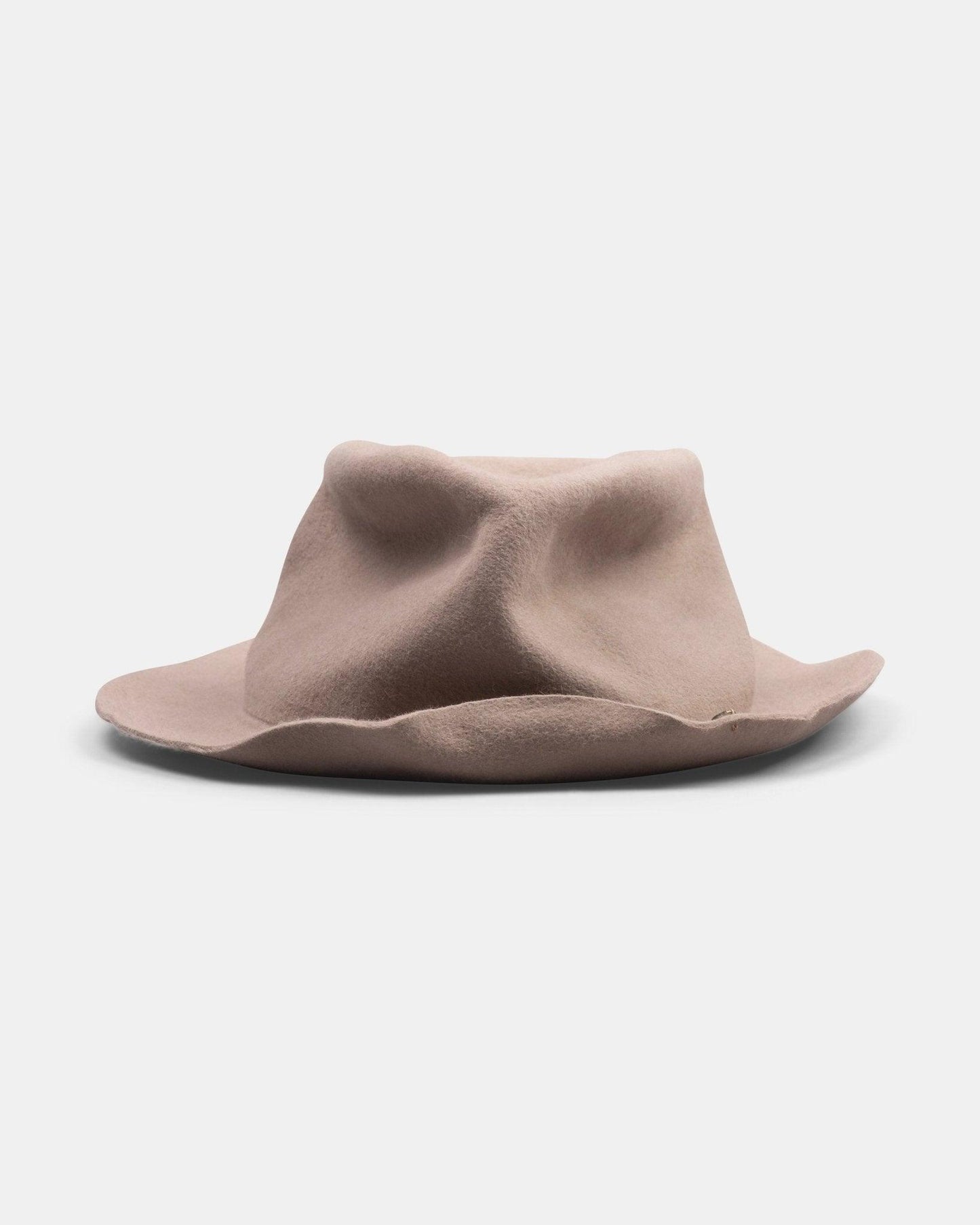 Light tan handmade felt hat with creased crown and wide, wavy brim on white background