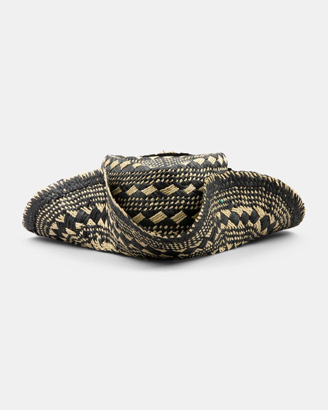 Handwoven black and beige straw hat with unique geometric pattern on white background