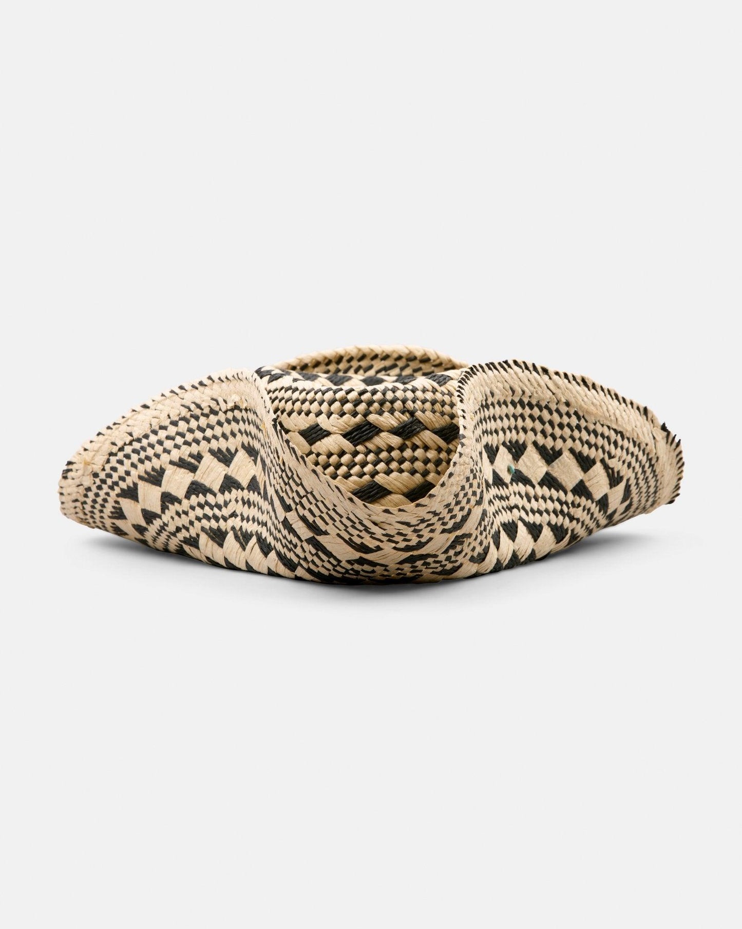 Handcrafted straw hat with black geometric woven pattern on a white background
